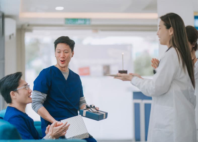 A group of coworkers having an office birthday party